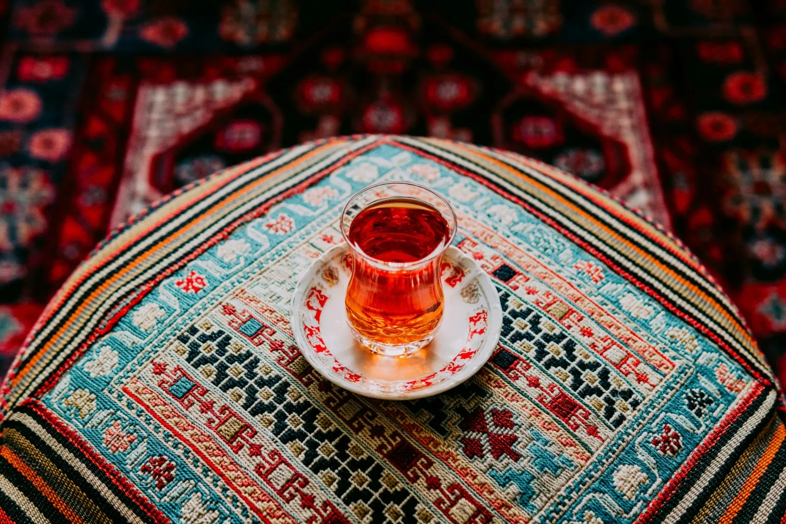 Verre de çay sur sa soucoupe, posé sur un tapis brodé
