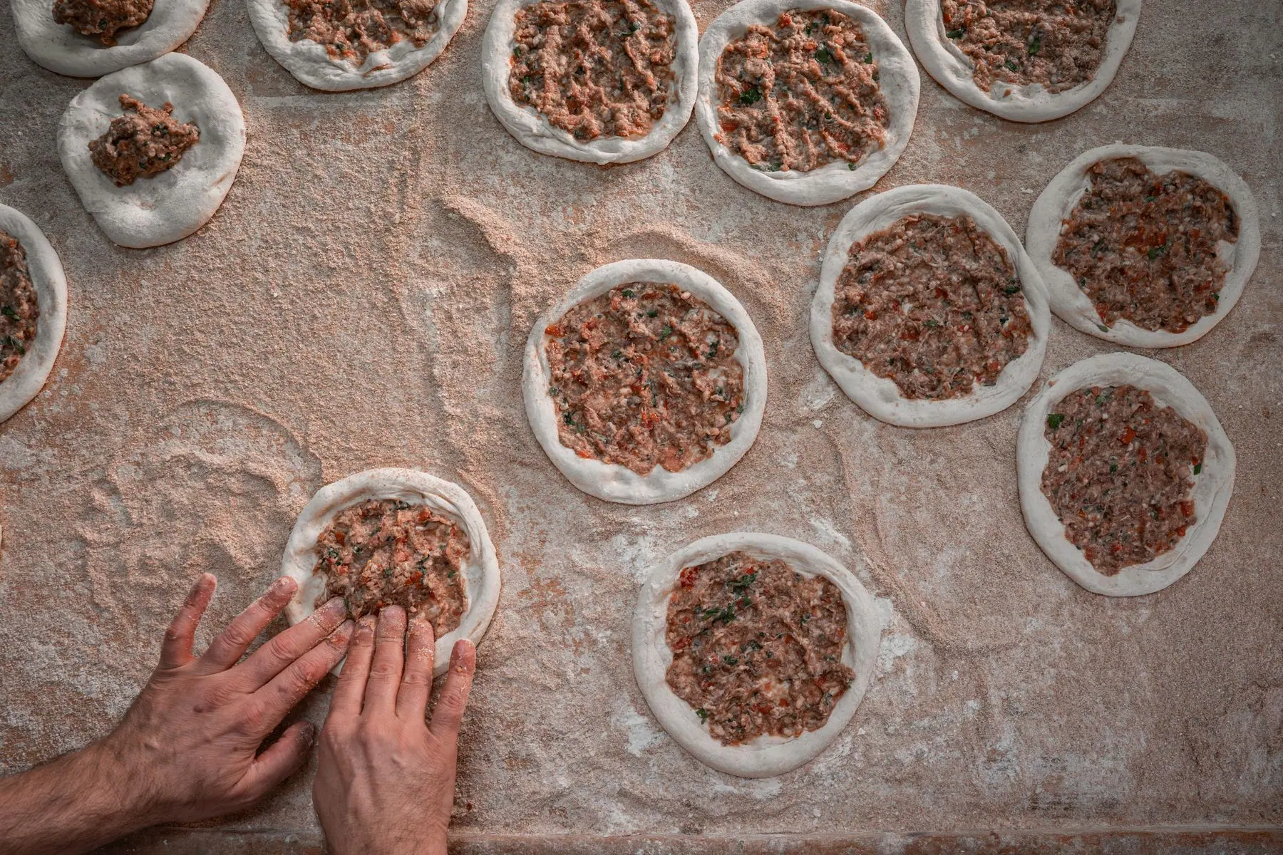 Mains qui préparent les lahmacun